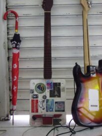 A guitarra de isopor no meio.