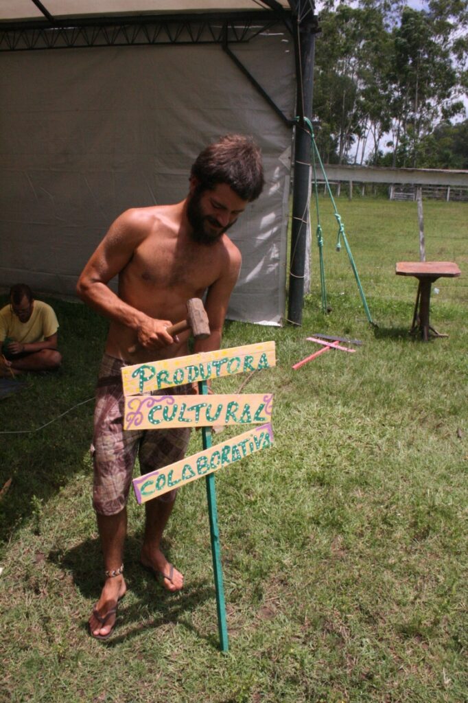 Mais a frente uma plaquinha menor para atrair os artistas que passam dentro e fora da aldeia da paz